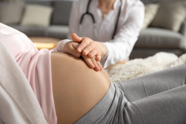 Lekarz-ginekolog wspiera kobietę w ciąży podczas badania.
