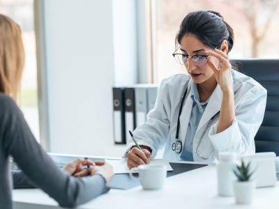 Pani doktor przeprowadzająca konsultację z pacjentem w gabinecie